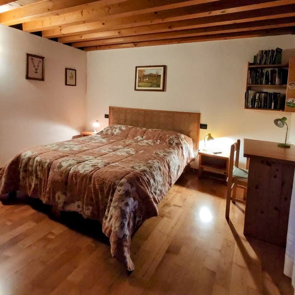 Camera matrimoniale dell'appartamento con letto e arredamento rustico
