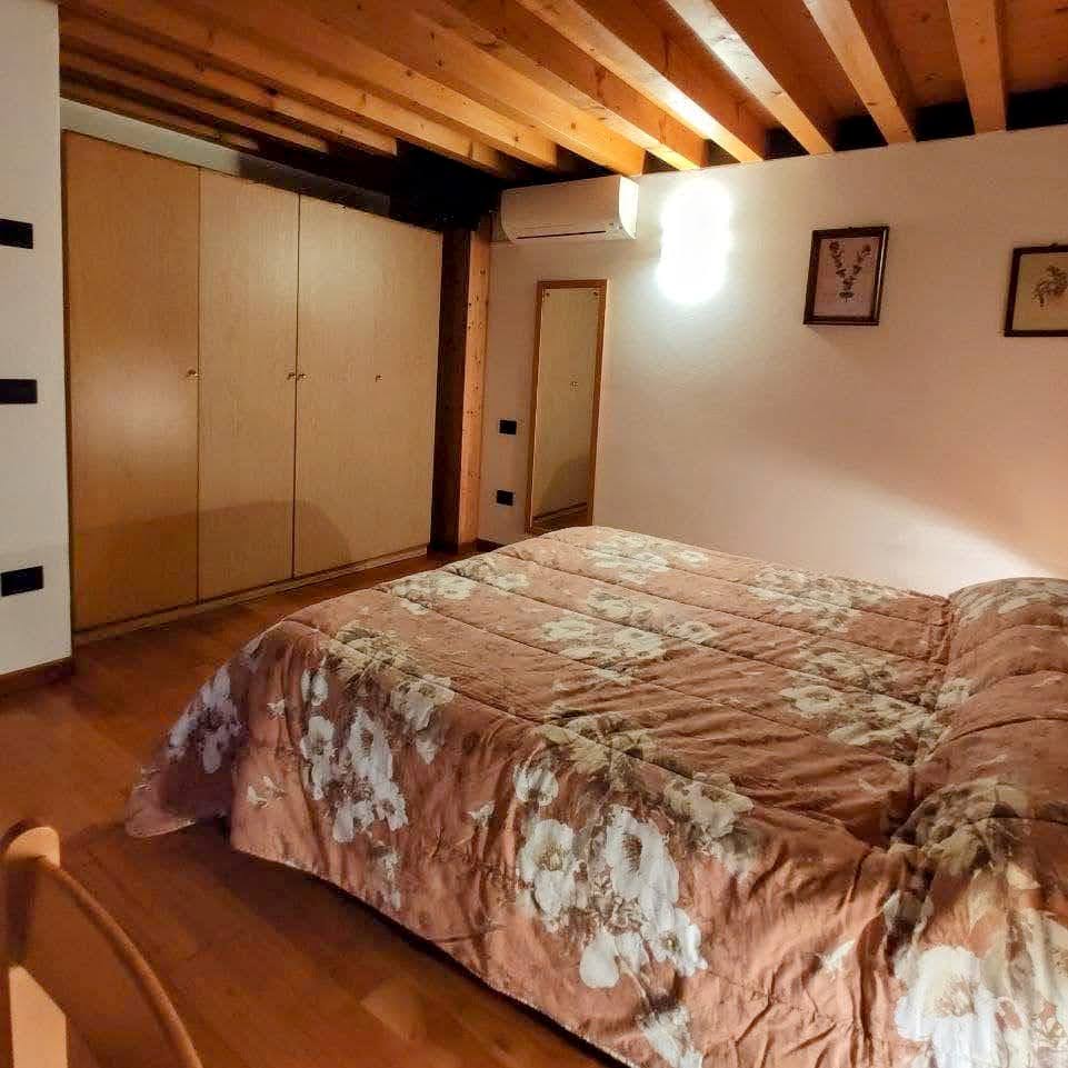 Camera matrimoniale dell'appartamento con letto e arredamento rustico