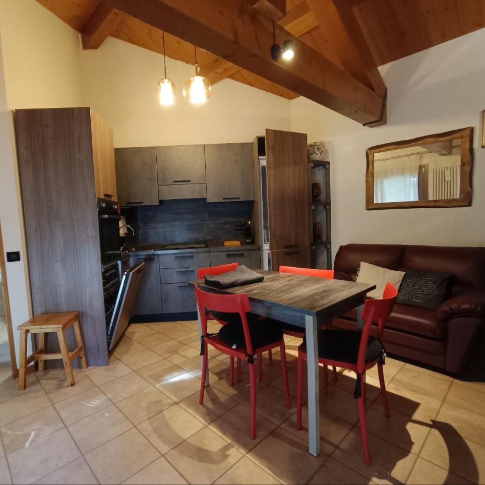 Cucina attrezzata del monolocale con piano cottura, forno e stoviglie